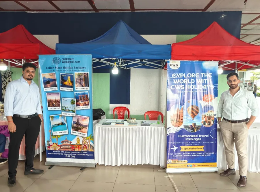 The CWS Holidays exhibition stand under a red and blue canopy, two colleagues standing beside the banners