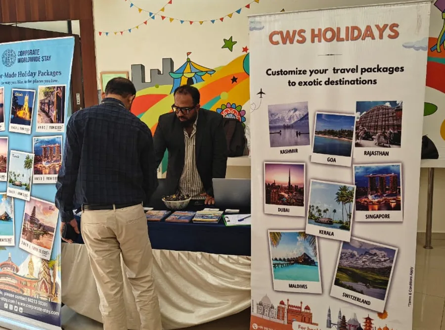 Visitors talking to CWS staff at a stand hung with destination banners