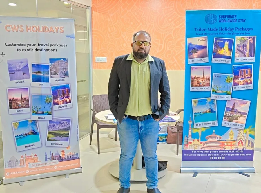 A colleague standing beside a CWS Holidays destination banner at the stand