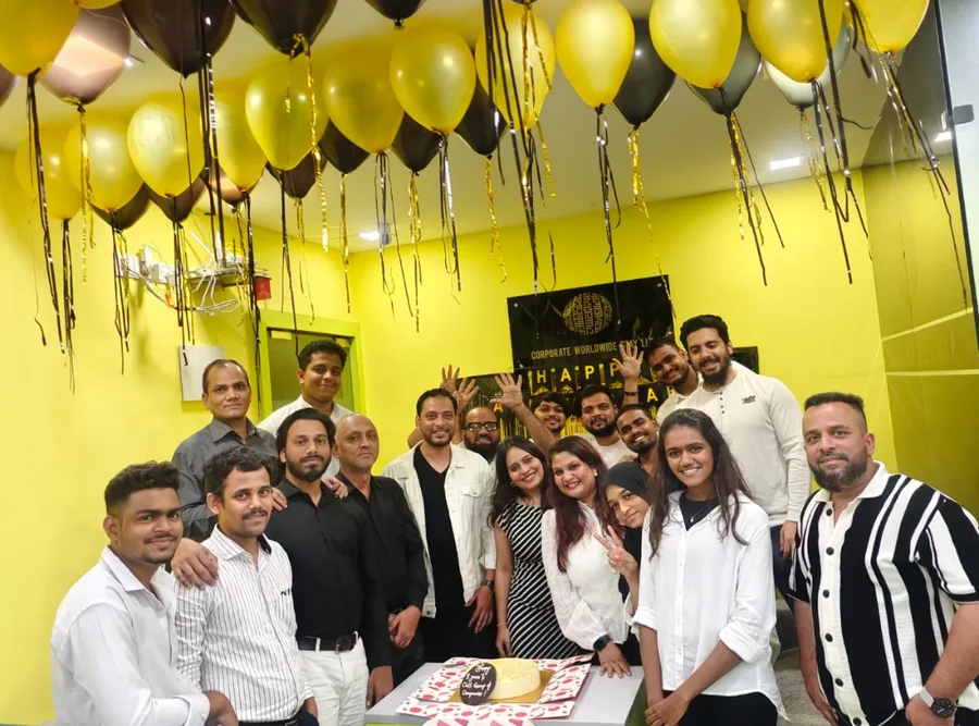 The team assembled under gold and black balloons for a company celebration
